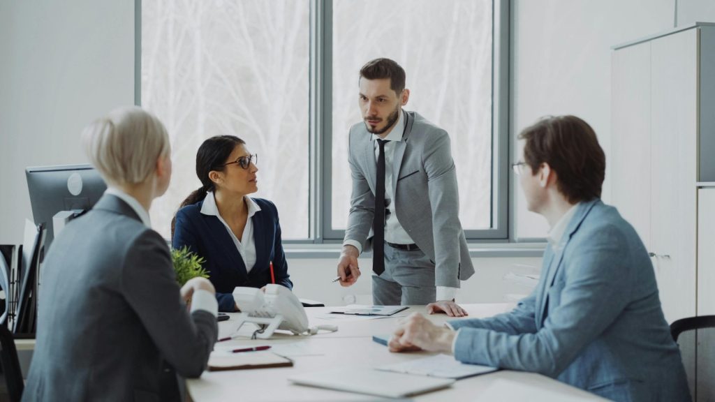Professionals engaged in a serious business discussion in a bright office environment.